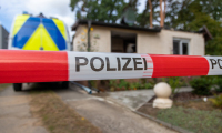 Abgebranntes Wohnhaus und Polizeifahrzeug