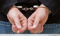 Handschellen an Handgelenken eines Straftäters